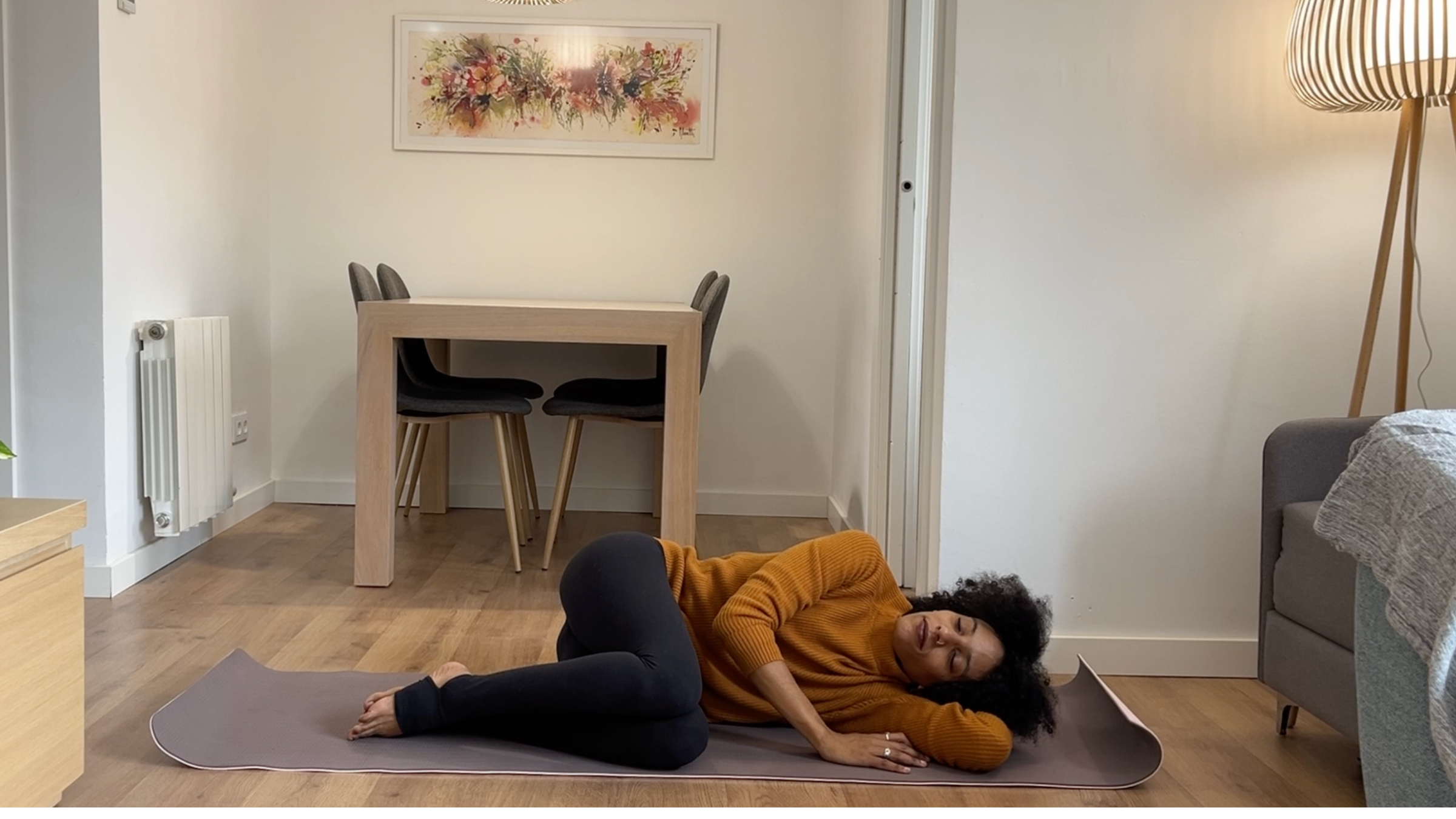 Laia Bové resting on her side in fetal position with stacked bent knees and head supported by her bottom arm.